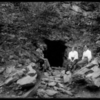 Mabel Wohlbrück and two others sitting at the entrance to a cave